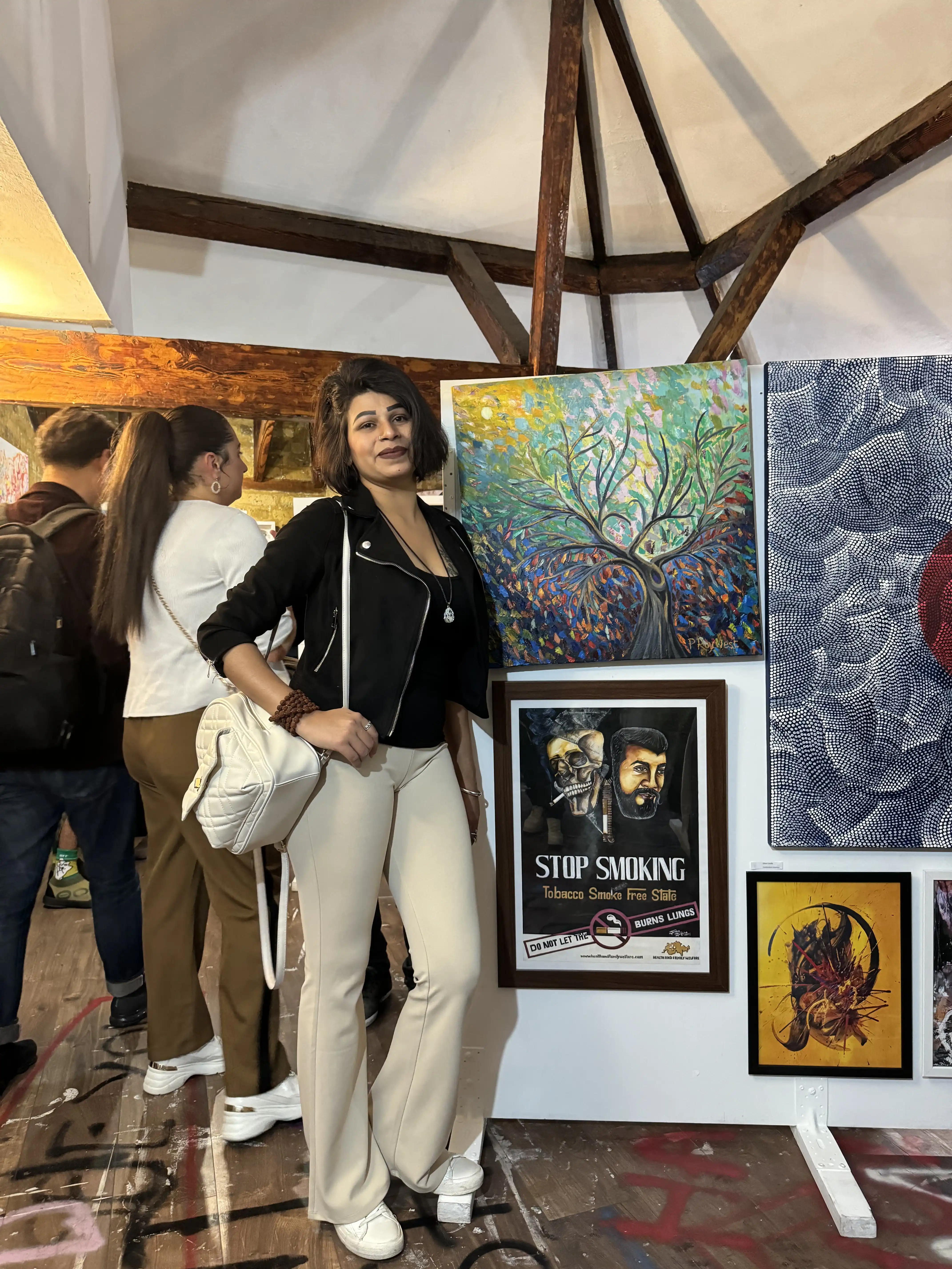 Sneha Solkhe standing with her artwork